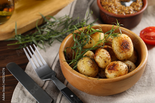 Delicious grilled potatoes with tarragon on table, closeup