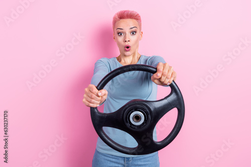 Photo of impressed astonished pretty girl with short hair dressed blue sweatshirt hold steering wheel isolated on pink color background