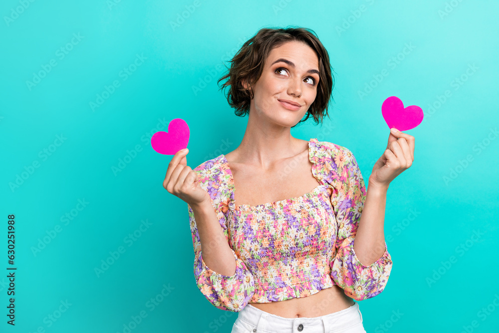 Photo of funny cheerful lovely woman wear colorful top hold pink paper hearts look empty space isolated on turquoise color background Photo of funny cheerful lovely woman wear colorful top hold pink paper hearts look empty space isolated on turquoise color background