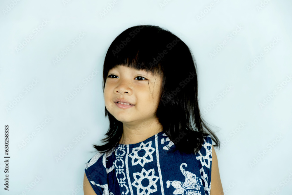 The portrait of a little child girl stands smiling looking into the camera's The portrait of a little child girl stands smiling looking into the camera's