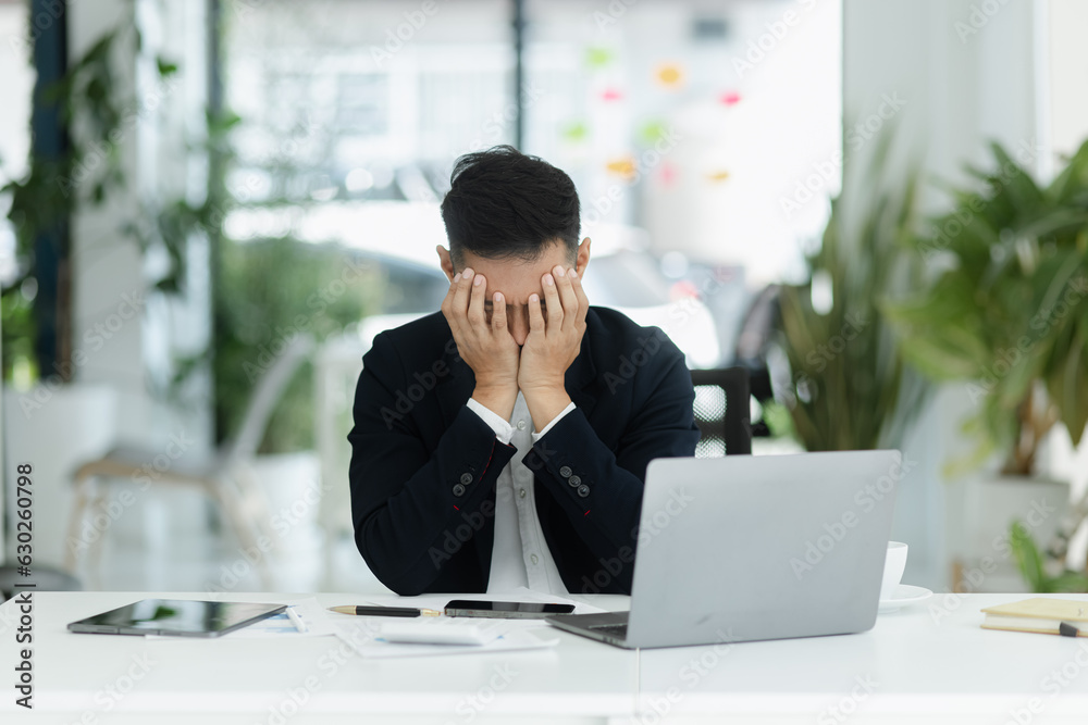 sad asian businessman sitting at desk in modern office, stressed man, problem, Worried young man businessman, 