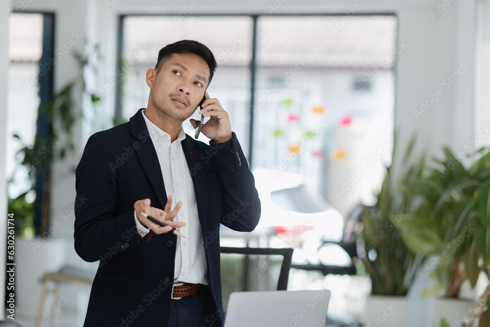 Portrait of candid happy asian businessman working in office. Portrait of candid happy asian businessman working in office.