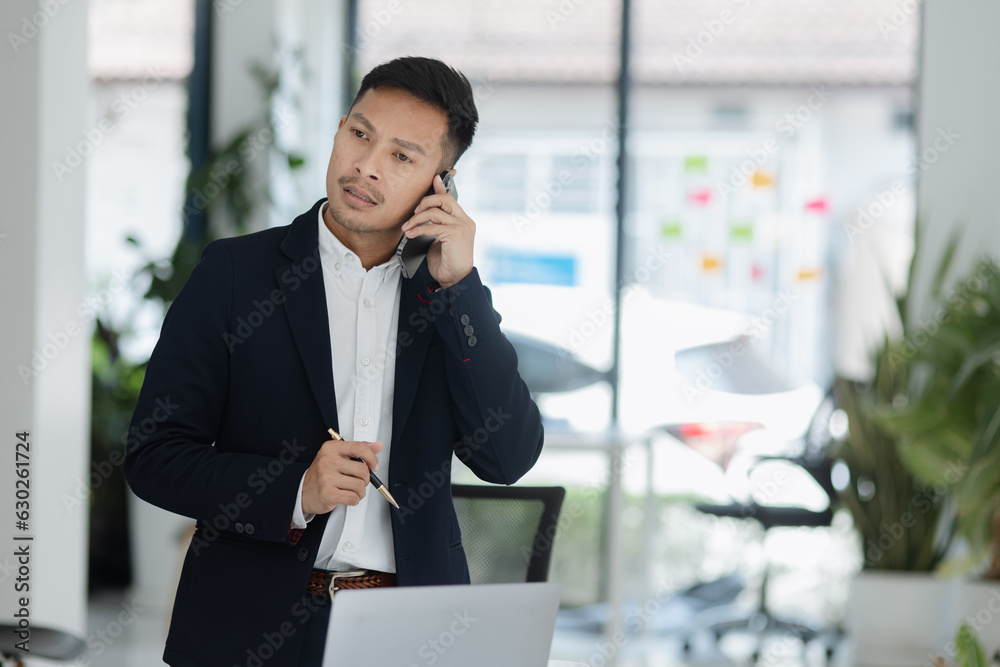 Portrait of candid happy asian businessman working in office. Portrait of candid happy asian businessman working in office.