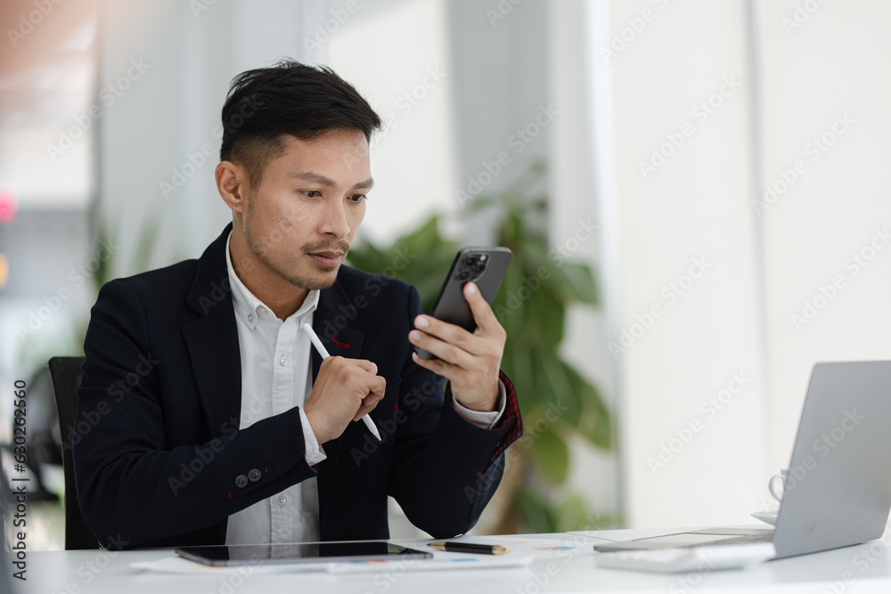 Portrait of candid happy asian businessman working in office. Portrait of candid happy asian businessman working in office.