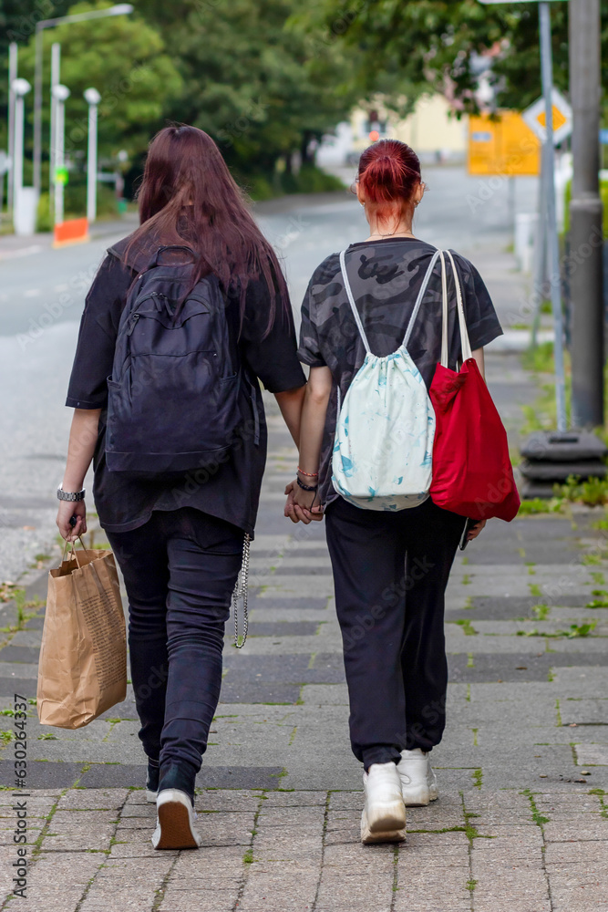 Two lesbians are walking down the street. Lesbian life. Happy girls Two lesbians are walking down the street. Lesbian life. Happy girls