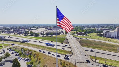 Large American Flag flying with Interstate 30 in the background.