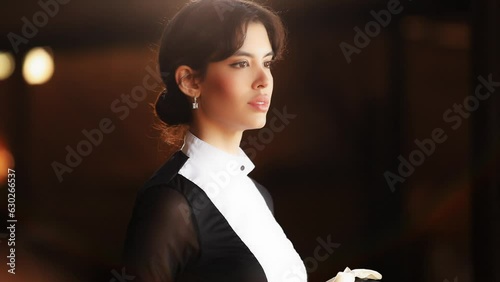 Portrait of Thoughtful Pretty Stylish Jockey Woman Horse Rider Show Performer Standing in a Horse Stable Holding Helmet  photo