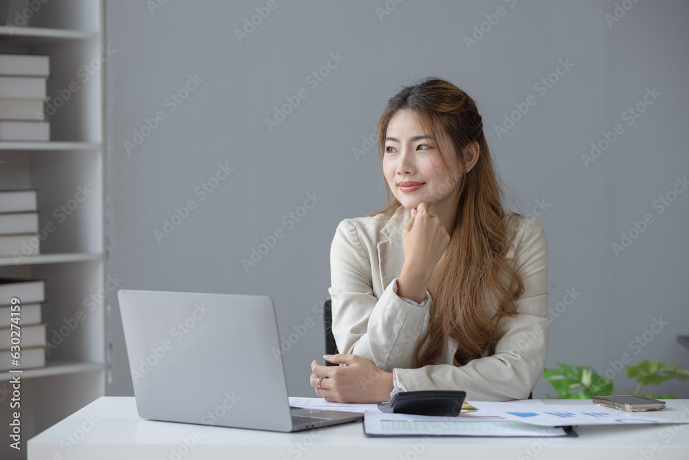 Smiling Asian businesswoman executive manager sitting at desk in office, Portrait of attractive professional asian businesswoman.