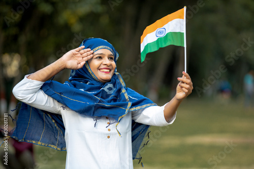 Indian woman waving and saluting of tricolor flag and celebrate national festival. photo