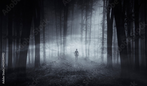 man in dark spooky forest at night  horror halloween background