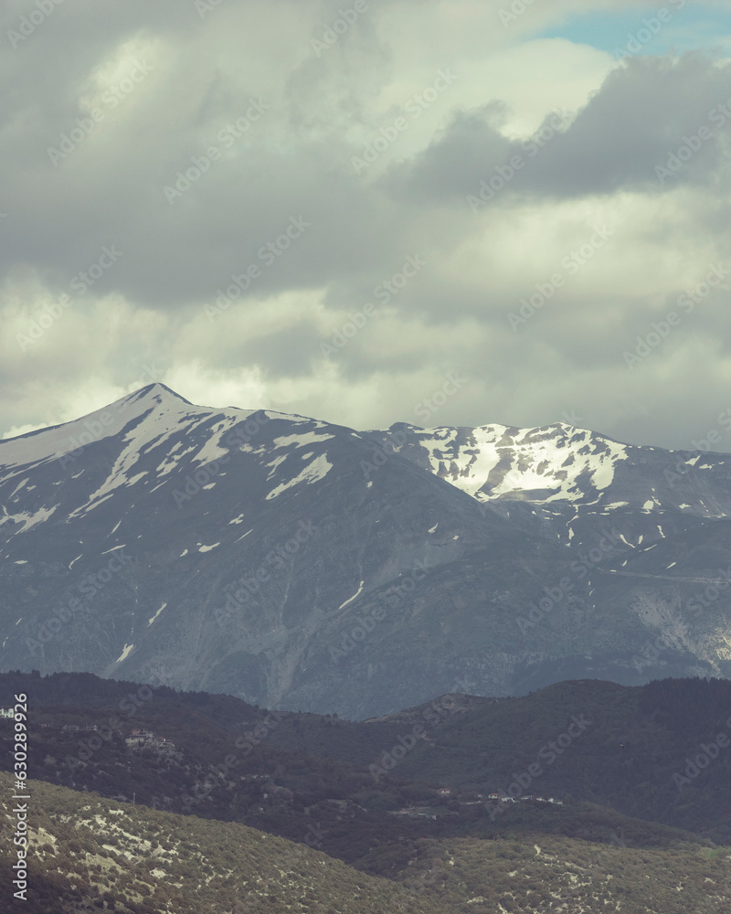 View of high mountain range with snow on the top along the Lake Pamvotida in Ioannina, Greece. View of high mountain range with snow on the top along the Lake Pamvotida in Ioannina, Greece.
