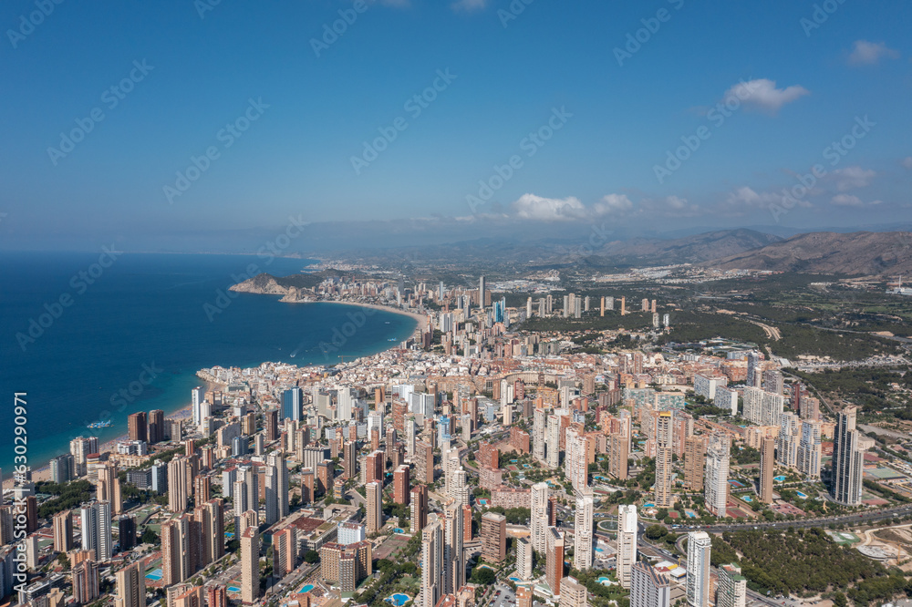 Aerial drone photo of the beautiful city of Benidorm in Spain in the summer time showing the Playa de Levante beach and the high rise apartments and hotels in the city in the summer time