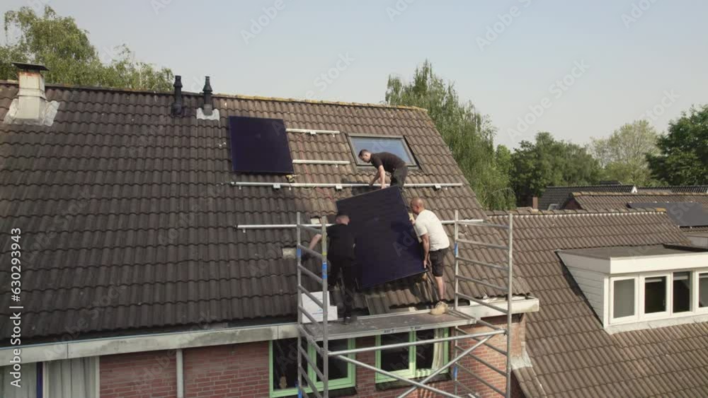 WS ZI Technicians fitting solar photo voltaic panels to house roof WS ZI Technicians fitting solar photo voltaic panels to house roof