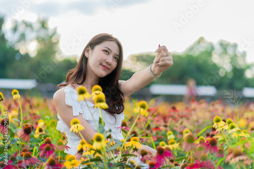 Beautiful Asian woman in a garden with beautiful colorful flowers Asian woman nature while relaxing in a flower garden, Chiang Mai, Thailand