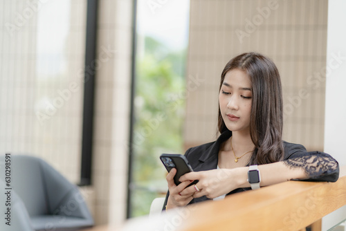 Free Download Beautiful successful asian businesswoman holding mobile phone using smartphone in office chatting with business mannequin  - GFXLoad