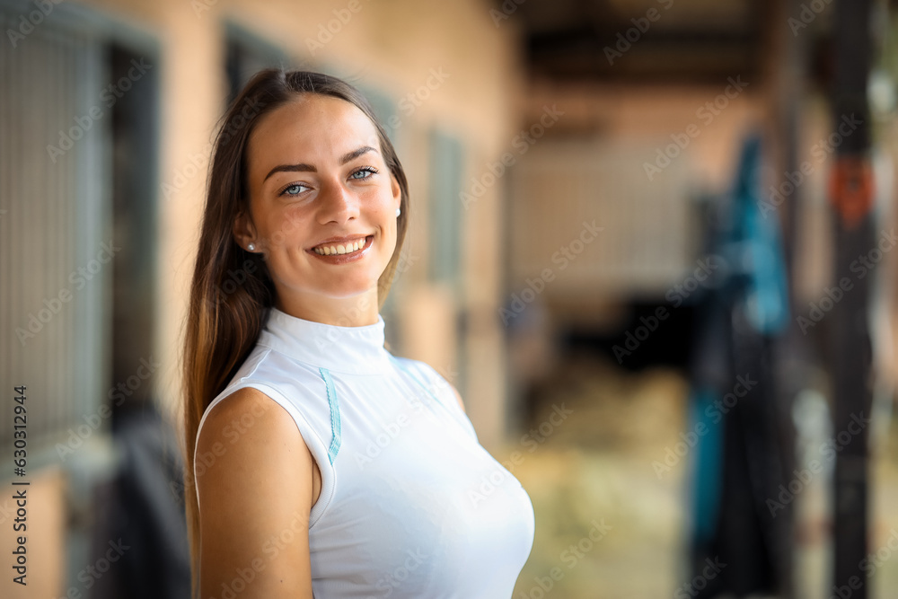 Woman young long hair brunette in riding clothes with a warm smile on her face, close up torso..
