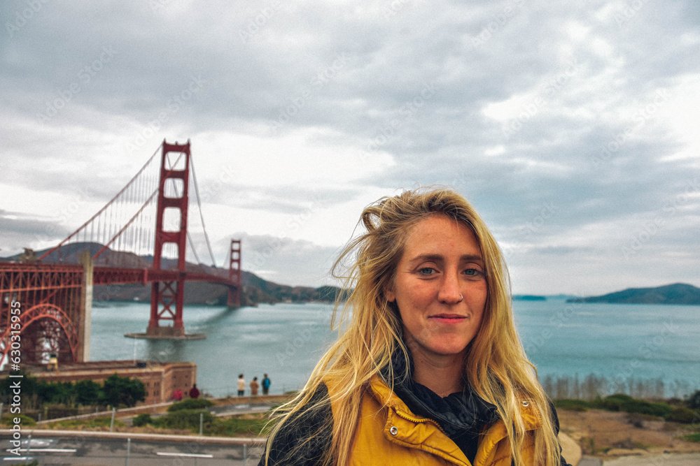 white and blonde woman poses with the golden gate bridge in the background white and blonde woman poses with the golden gate bridge in the background