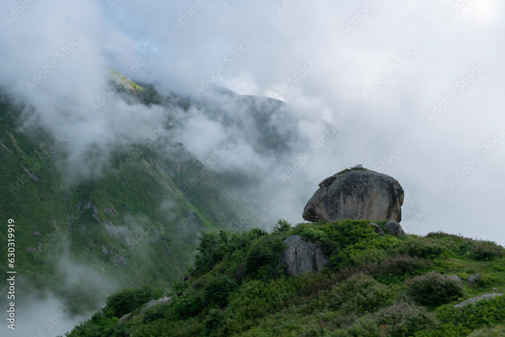 Cloudy mountains.
Mountains in clouds at sunrise in summer. Aerial view of mountain peak with green trees in fog. Top view of mountain valley in low clouds from drone. Rize Huser plateau, Türkiye
