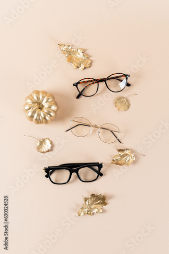 Eyewear and glasses sale concept. Trendy sunglasses on beige background with a pumpkin and golden leaves. Trendy Fashion fall accessories. Vertical. Autumn sale. Optic store discount poster