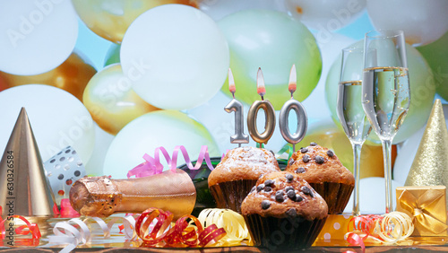 Happy birthday champagne background with number of candles  100. Beautiful congratulations copy space for anniversary..Festive decorations with a bottle of champagne in pastel colors. photo