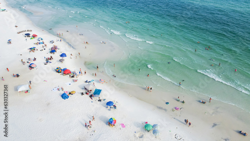 Colorful beach chairs, umbrellas and people swimming, relaxing laid-back, less crowded experience along white sandy beaches, turquoise water, gorgeous shade of blue Santa Rosa, Florida, USA