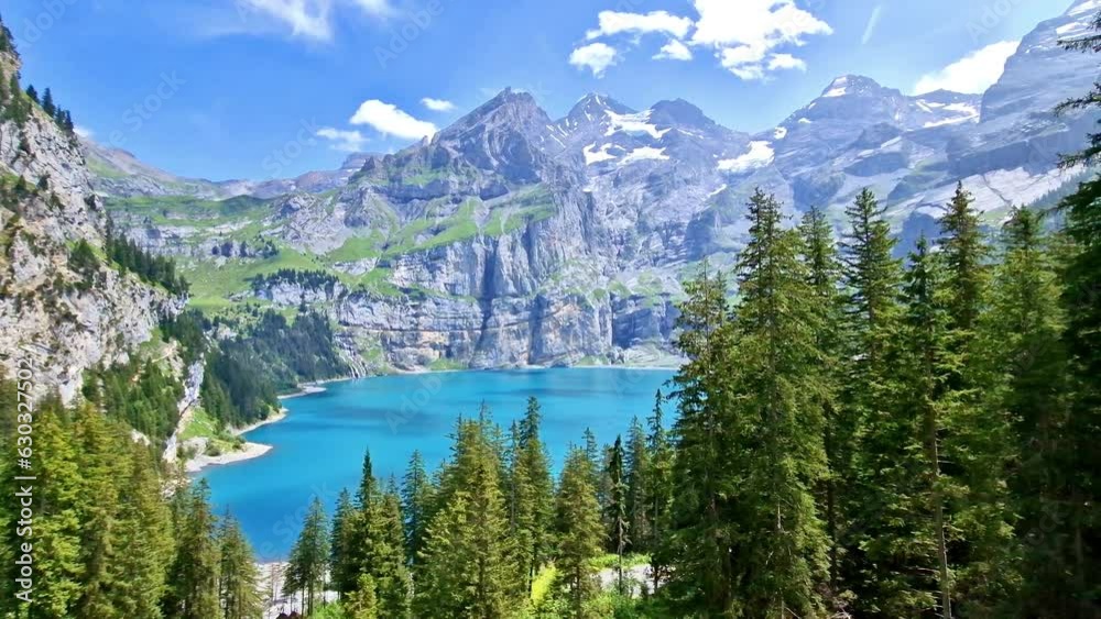 Idyllic swiss mountain lake Oeschinensee (Oeschinen) with turquise water and snowy peaks of Alps mountains near Kandersteg village. Switzerland nature scenery