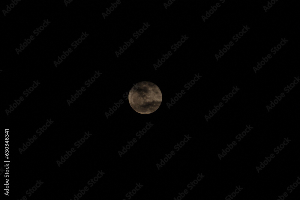A super full moon that was slightly obscured by clouds and had a dark background. A super full moon that was slightly obscured by clouds and had a dark background.