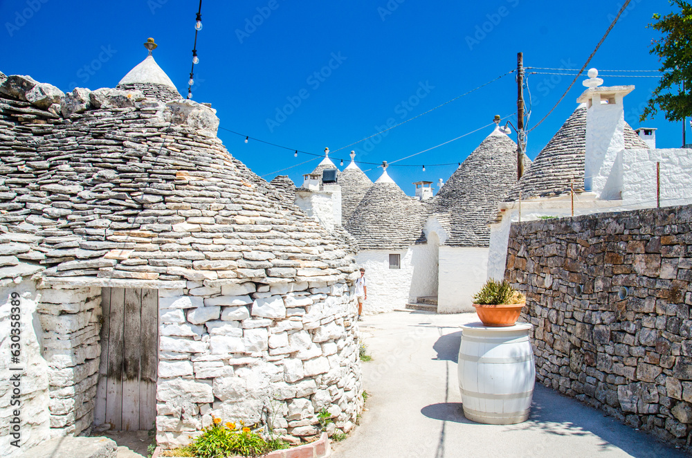 Old street with white houses and conical roofs in Alberobello, Puglia, Italy