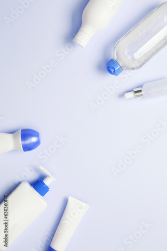Cosmetic beauty products on blue background. Bottles and tubes with branding mock up. Skin care and beauty concept. Top view, flat lay, copy space