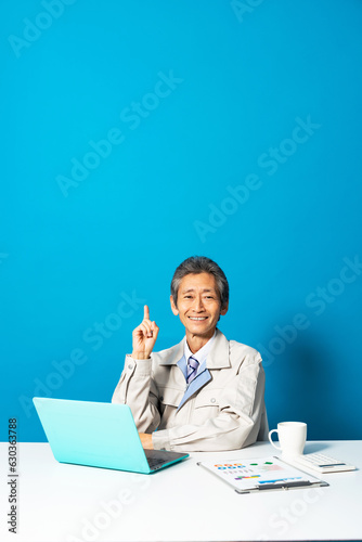 パソコンを使う作業服を着た男性