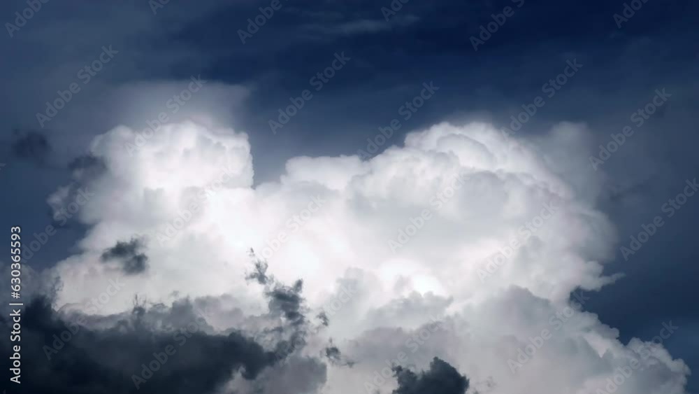 Time-lapse footage of huge white cumulonimbus cloud expanding and rising up in the blue sky. Cloudscape