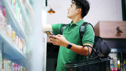 Grocery delivery service shopper with insulated delivery bag buying items for customers at supermarket. Asian man rider selecting food supply for client order. Personal shopper concept