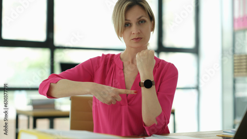 Business manager points to the clock at workplace. Time management and time planning