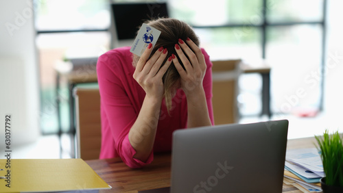 Worried woman having trouble shopping online using credit card and laptop. Theft of money from bank card in online network and cybercrime