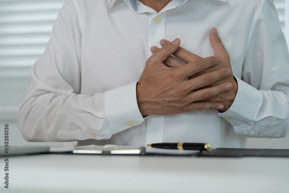 hand hold chest with heart attack symptoms, asian man working hard have
