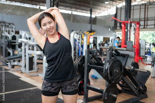 Asian woman stretching and warming up before exercising at fitness cente