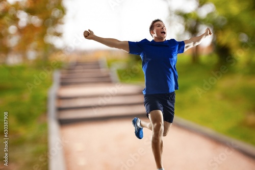 Cheerful and successful sporty man jogging outdoor