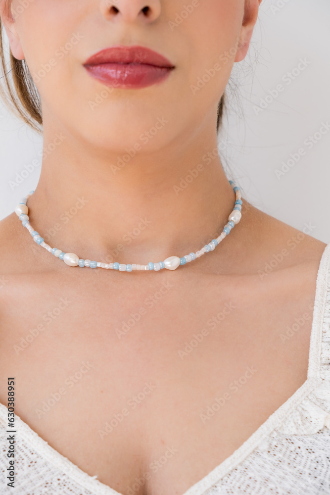 Young woman wearing a necklace with beads.