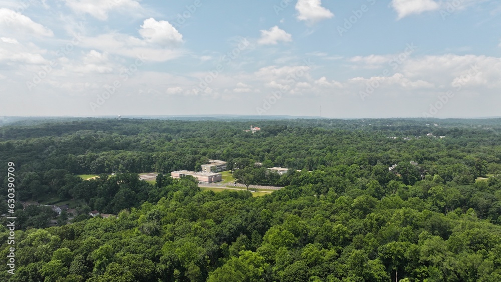 Aerial shot of a church standing atop a hill surrounded by lush trees in Hartsdale, New York.