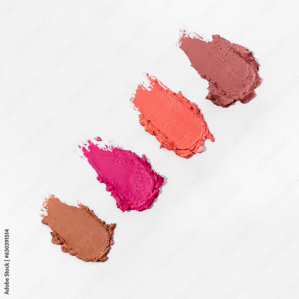 Close-up of a collection of colorful lipstick samples on a white background