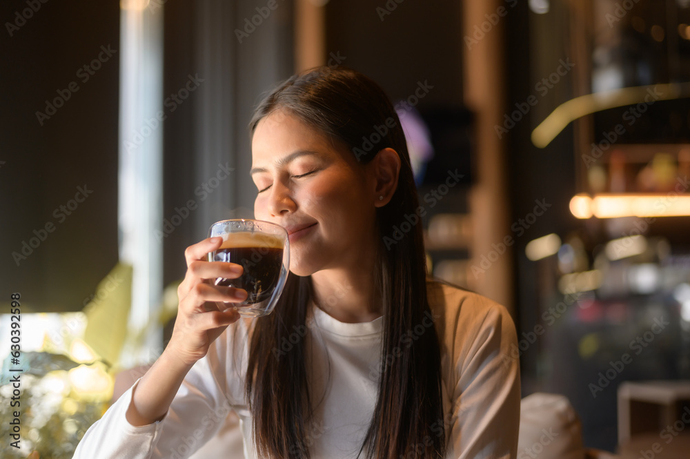 A young woman drinking coffee in modern coffee shop