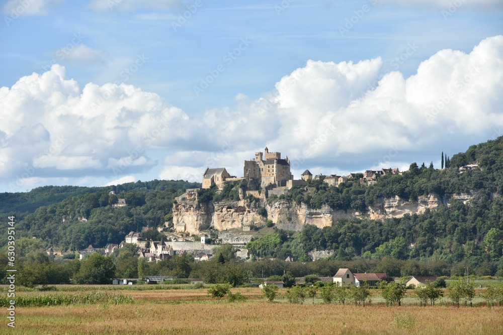 Picturesque scene of a castle in Beynac-et-Cazenac, France against the cloudy blue sky