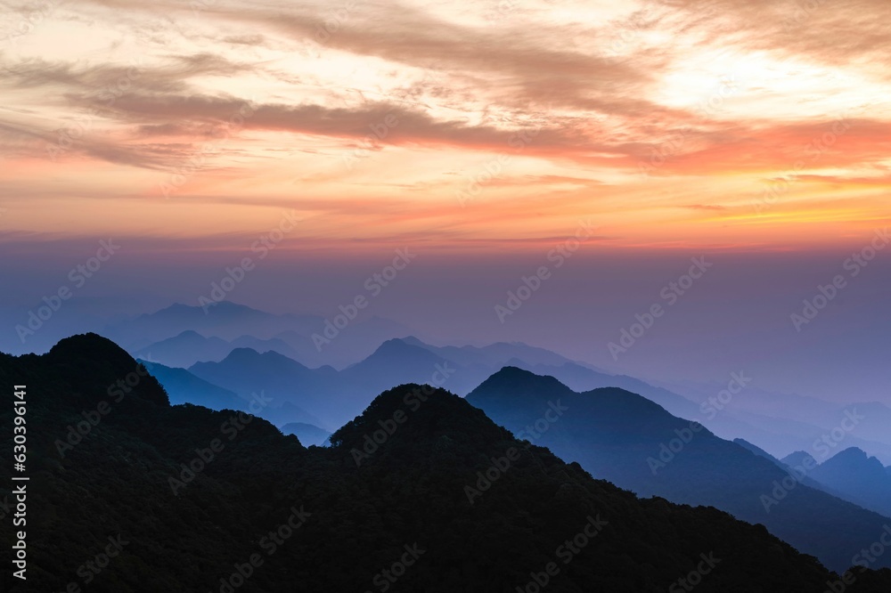 Stunning landscape of mountain ranges silhouetted against a vibrant sunrise