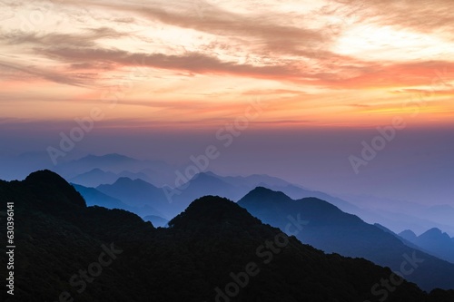 Stunning landscape of mountain ranges silhouetted against a vibrant sunrise