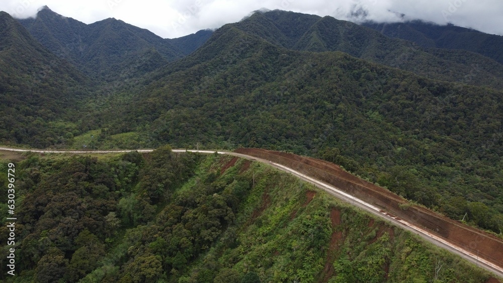 Scenic view of an empty highway winding through a mountain landscape Scenic view of an empty highway winding through a mountain landscape