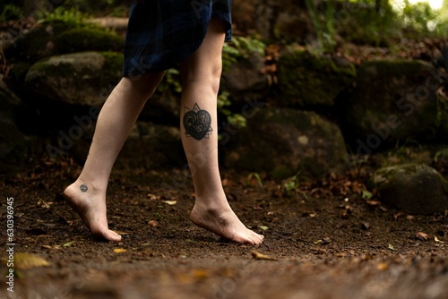 Feet of a person walking through a lush forest while
