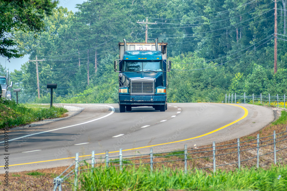 Heavy Truck Negotiates Curve On Rural Blacktop Road