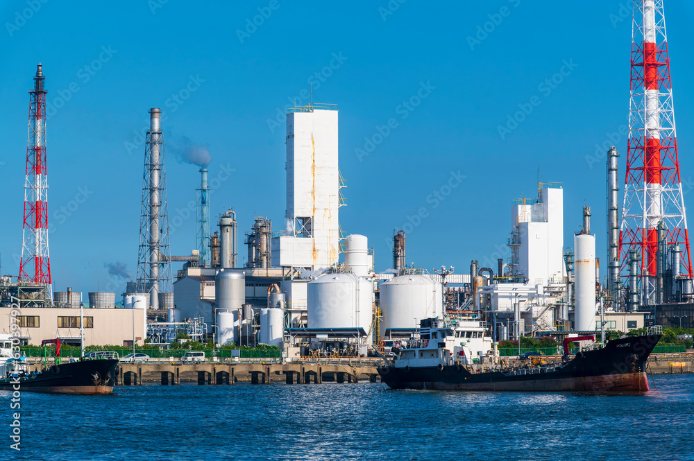 Industrial petrochemical refinery with gas storage and structure of pipeline with smoke from smokestack plant form industry chemical factory zone with blue sky background view, Japan