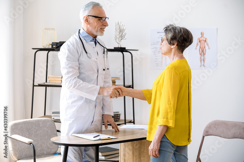 male physician shaking hand with female patient at appointment