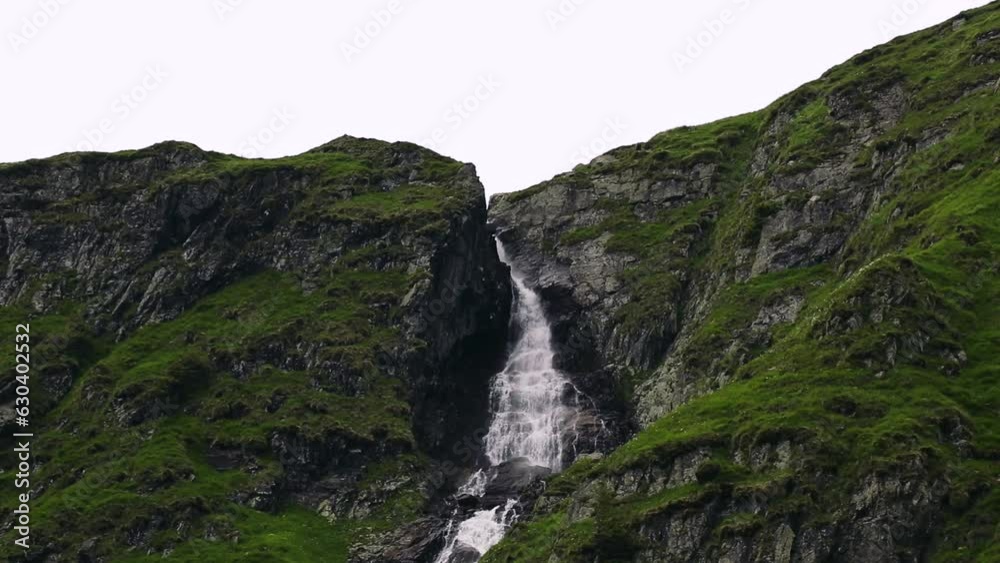 Beautiful foamy waterfall coming down the big cliffs and rocks Beautiful foamy waterfall coming down the big cliffs and rocks